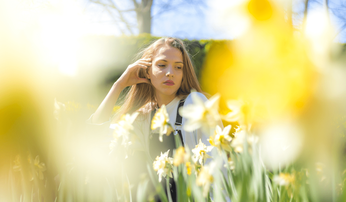 Chica joven posando en un campo de flores.